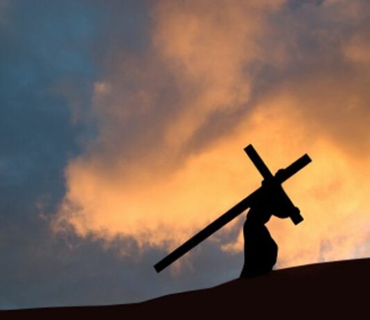 The cross A picture representation of Jesus carrying the cross on a hill